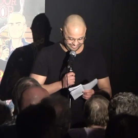 Badr op het podium gefotografeerd tussen het publiek door.