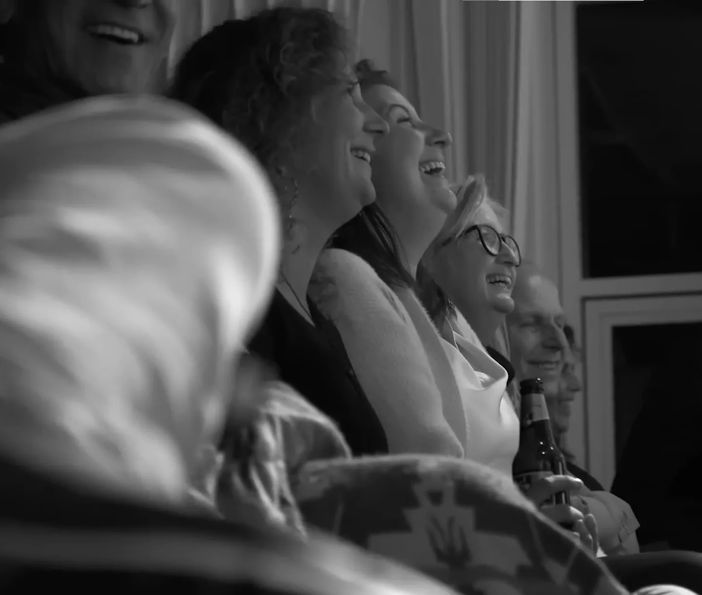 Comedian op het podium met een zaal die zichtbaar mee is in de avond.